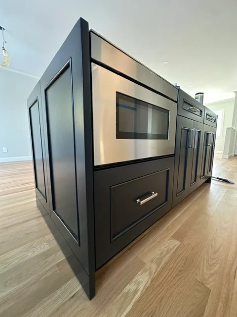 Kitchen island with a built-in microwave drawer and shaker cabinet doors
