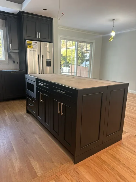 Custom dark kitchen island with built-in drawers in a residential remodel