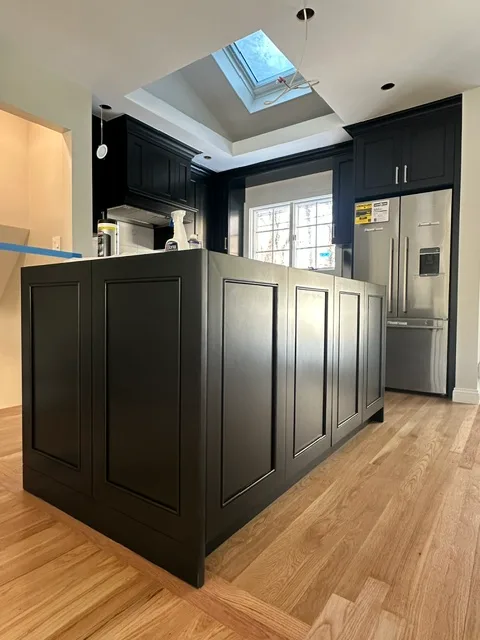 Kitchen remodel with island under a skylight by Elite Construction Group