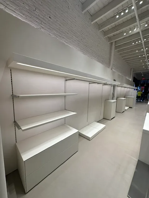 Wall-mounted shelving system and white base cabinets in a retail build-out